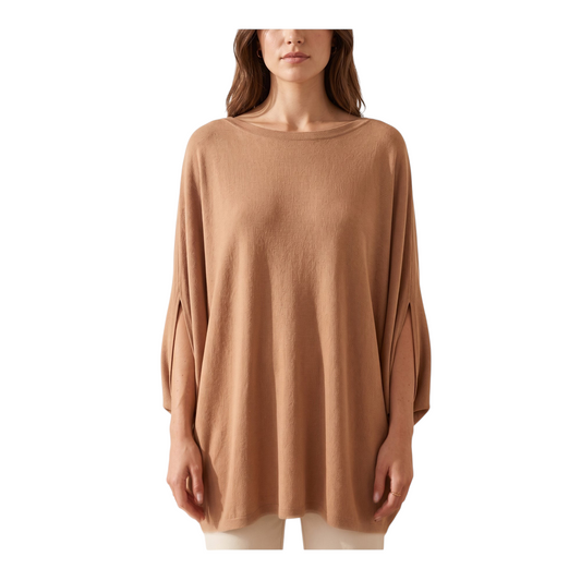 Modella indossa una maglia a mantella color cammello di Peg Fashion Store con maniche ampie e scollo a barchetta
