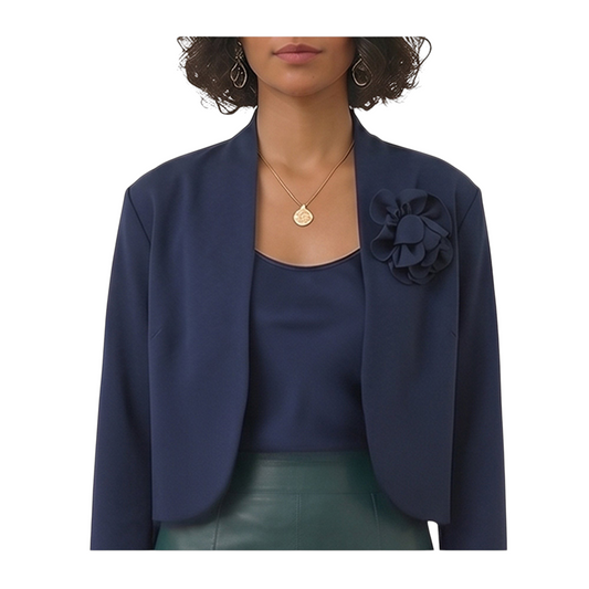 Giacca Peg Fashion Store in cotone blu con spilla a forma di camelia indossata su top coordinato
