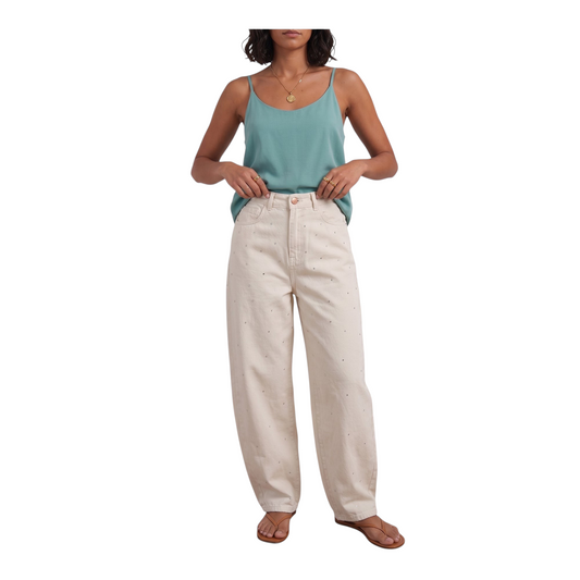 Modella indossa jeans palazzo color crema con applicazioni di Peg Fashion Store abbinati a un top verde acqua