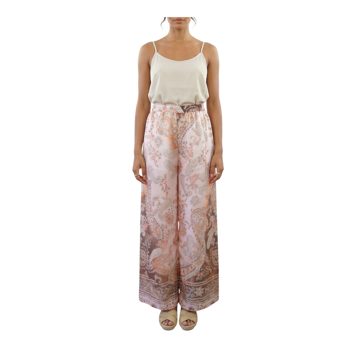 Modella indossa pantaloni Peg Fashion Store in mussola con stampa paisley sui toni del rosa e marrone a gamba larga