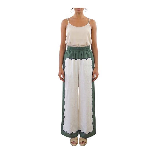 Modella indossa pantaloni Peg Fashion Store in lino a gamba larga con motivo geometrico a smerlo verde e bianco