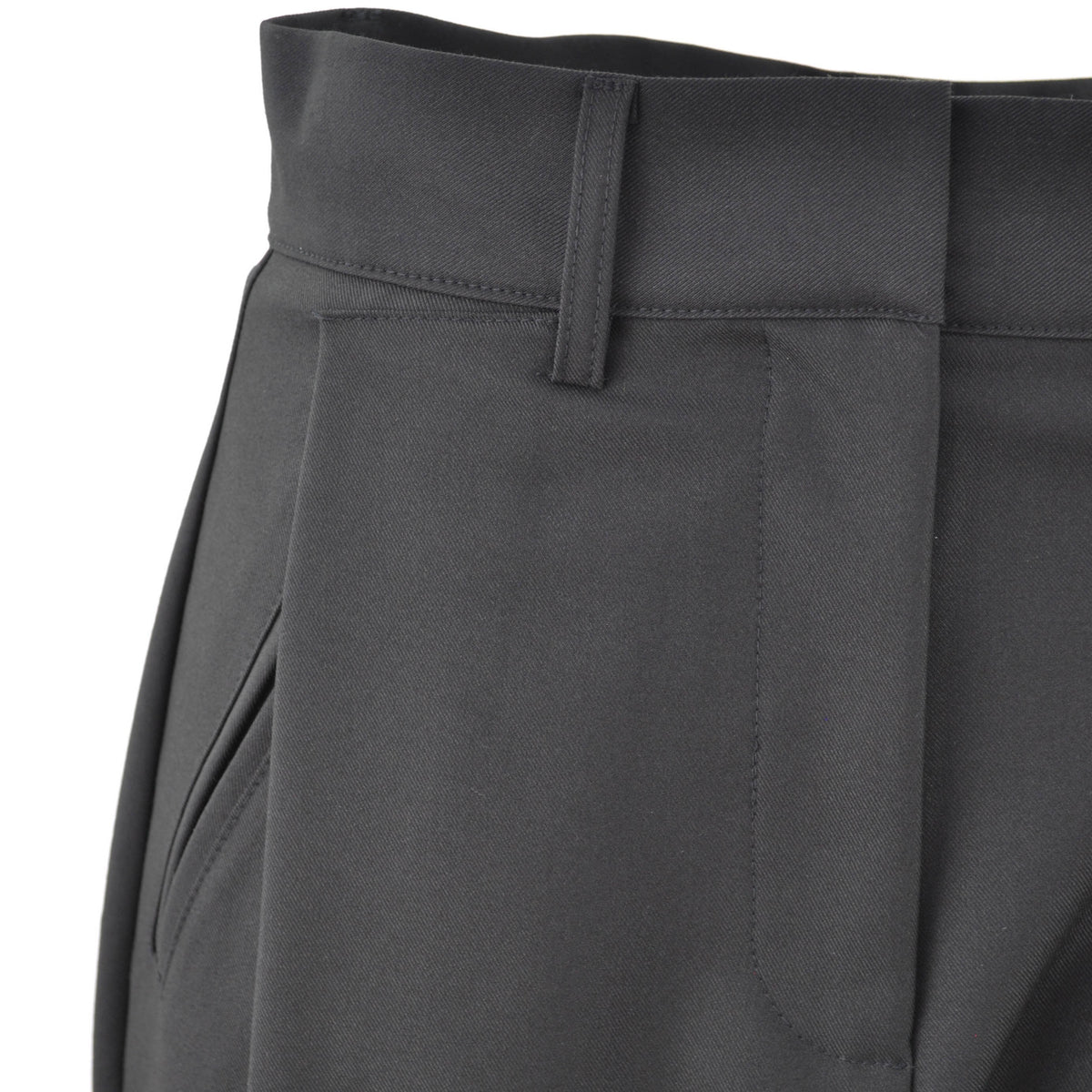 Dettaglio della vita di un pantalone nero Peg Fashion Store con piegoni frontali e passanti per cintura