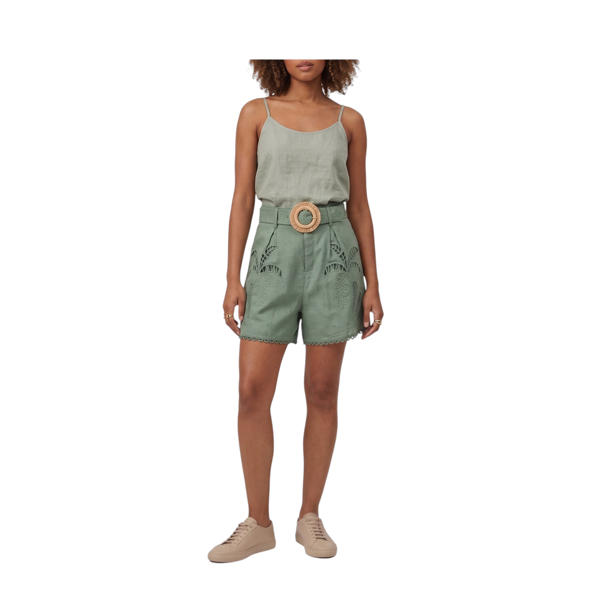 Modella indossa shorts Peg Fashion Store in lino verde con ricami floreali e cintura con fibbia rotonda in legno