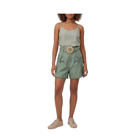 Modella indossa shorts Peg Fashion Store in lino verde con ricami floreali e cintura con fibbia rotonda in legno